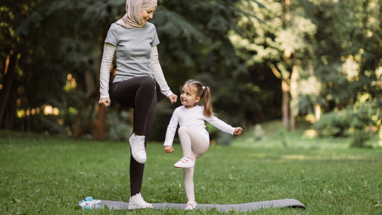 Family enjoying outdoor exercise in a park. Healthy living, connection and wellbeing inspired by Qiddiya City